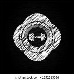 big dumbbell icon inside chalkboard emblem on black board