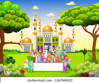 the big happy family are holding the blank banner near the mosque