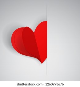 Big red heart inserted into a cutout in a sheet of white paper