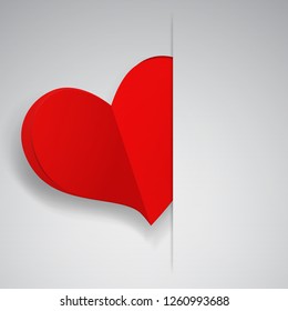 Big red heart inserted into a cutout in a sheet of white paper