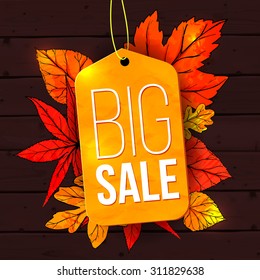 Big sale banner with autumn leaves and yellow tag on wooden background. Fall sale vector design for retail advertisement campaigns.