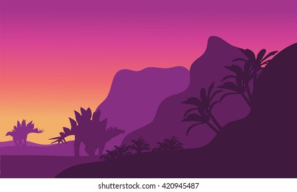 Big stegosaurus dinosaur in hills of silhouettte