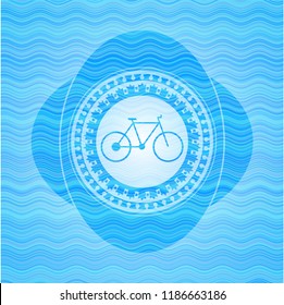 bike icon inside light blue water wave badge.