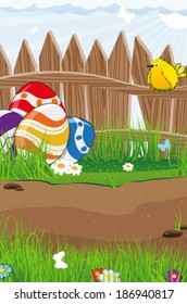 Bird and colorful Easter eggs near a wooden fence on a spring meadow
