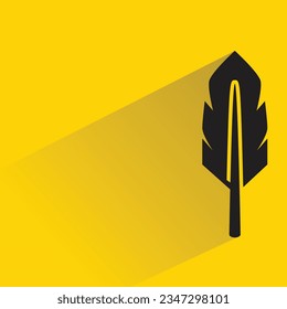 bird feather with shadow on yellow background
