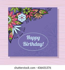 Birthday card with flowers in corner on wooden background