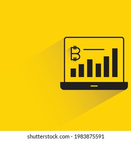 gráfico de bitcoin en portátil con sombra sobre fondo amarillo