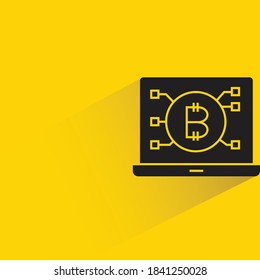 bitcoin on laptop with drop shadow on yellow background