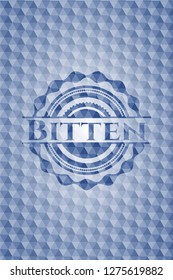 Bitten blue badge with geometric pattern.