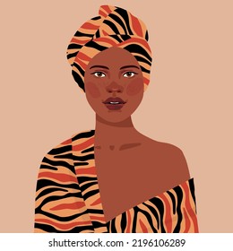 Black African  girl is wearing a animal tiger print turban. Self-confident young woman with brown skin in traditional headdress portrait front view. 