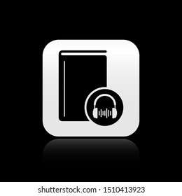 Black Audio book icon isolated on black background. Book with headphones. Audio guide sign. Online learning concept. Silver square button. Vector Illustration
