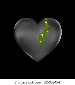 black background and the large stone wounded heart-stone with traces and flowering grass