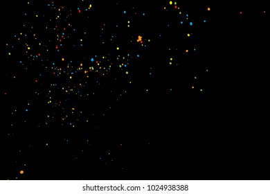 Black background with many falling tiny round random confetti, glitter and serpentine pieces blow and sprayed on dark background. Isolated.