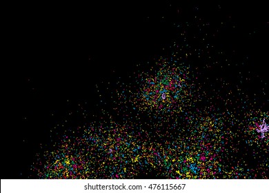 Black background with many falling tiny round random confetti, glitter and serpentine pieces blow and sprayed on distressed background. Isolated.