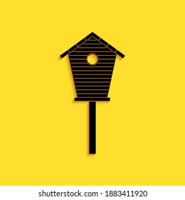 Black Bird house icon isolated on yellow background. Nesting box birdhouse, homemade building for birds. Long shadow style. Vector.