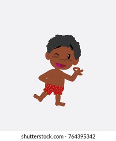 Black boy in a swimsuit doing the OK sign with his hand.
