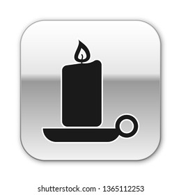 Black Burning candle in candlestick icon isolated on white background. Old fashioned lit candle. Cylindrical aromatic candle stick with burning flame. Silver square button. Vector Illustration