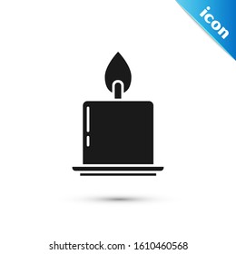 Black Burning candle in candlestick icon isolated on white background. Cylindrical candle stick with burning flame.  Vector Illustration