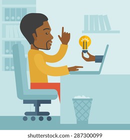 A black businessman sitting while working infront of his desk getting a brilliant idea for business from the laptop. Business concept. A contemporary style with pastel palette soft blue tinted