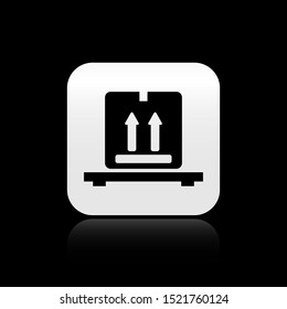 Black Cardboard boxes on pallet icon isolated on black background. Closed carton delivery packaging box with fragile signs. Silver square button. Vector Illustration