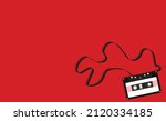 black cassette with tape out on red background