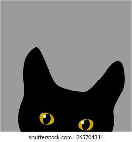 Black cat with yellow eyes hiding