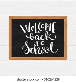 Black chalkboard with hand drawn quote Welcome back to school, vector illustration