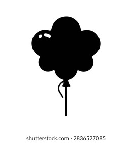 A black cloud-shaped balloon with a string floating freely against a plain background, symbolizing creativity and imagination.