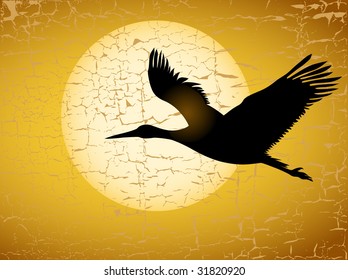The black crane on a background of the big round heated evening sun flies on the sky