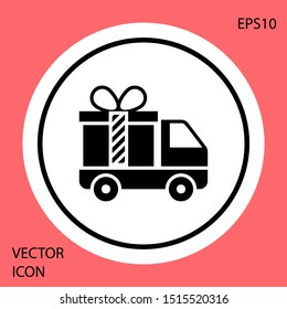 Black Delivery truck with gift icon isolated on red background. White circle button. Vector Illustration