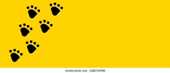 Black dog or cat pet footprint tracks on bright yellow background. Animal and pet concept.