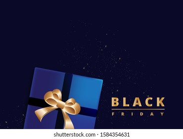 Black Friday sale. Gift box decorated with gold bow on dark blue background. Top view. 
