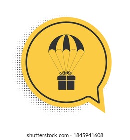 Black Gift box flying on parachute icon isolated on white background. Delivery service, air shipping concept, bonus concept. Yellow speech bubble symbol. Vector.