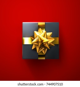 Black gift box with glittering golden bow and ribbons isolated on red background. Vector realistic festive illustration. Decoration element for holiday design. Top view