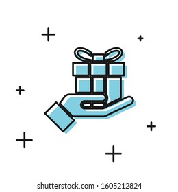 Black Gift box in hand icon isolated on white background. Merry Christmas and Happy New Year.  Vector Illustration