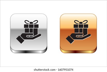 Black Gift box in hand icon isolated on white background. Merry Christmas and Happy New Year. Silver-gold square button. Vector Illustration