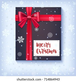Black gift box with red bow and ribbon on snow backdrop. Congratulations card of Merry Christmas on snowy and frosty background. Template for your cover, poster, 3D illustration.