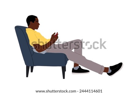 Black Guy sitting in armchair, using smart phone.