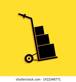 Black Hand truck and boxes icon isolated on yellow background. Dolly symbol. Long shadow style. Vector.