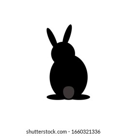 the black hare is sitting with his back turned