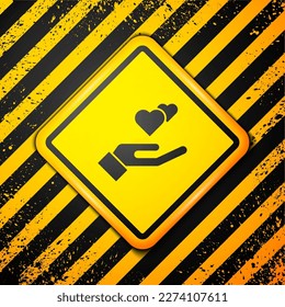 Black Heart in hand icon isolated on yellow background. Hand giving love symbol. Valentines day symbol. Warning sign. Vector