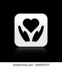 Black Heart on hand icon isolated on black background. Hand giving love symbol. Valentines day symbol. Silver square button. Vector Illustration