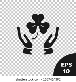 Black Human hands holding four leaf clover icon isolated on transparent background. Happy Saint Patrick day.  Vector Illustration