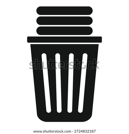Black laundry basket overflowing with a pile of dirty clothes, ready for the washing machine
