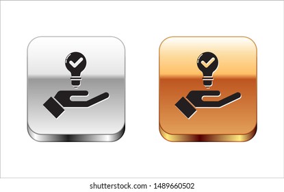 Black Light bulb in hand icon isolated on white background. Concept of idea. Silver-gold square button. Vector Illustration