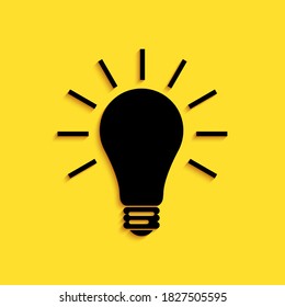 Schwarze Glühbirne mit Strahlen glänzt Symbol einzeln auf gelbem Hintergrund. Energie- und Ideensymbol. Lampe elektrisch. Lange Schattenstil. Vektorgrafik.