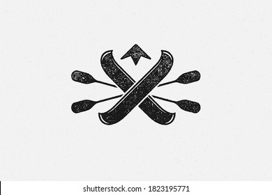 Black logo of oars and kayaks crossed against mountain peak silhouette hand drawn stamp effect vector illustration. Vintage grunge texture on old paper for poster or label decoration.