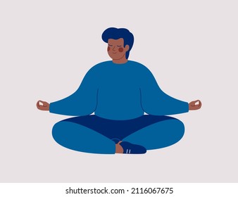 Black man sits with cross-legged on the floor and meditates with closed eyes. African American male makes morning yoga, relaxes at home or breathing exercises. Body positive, health care concept.