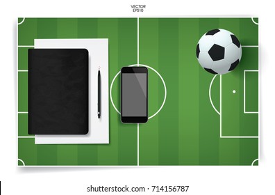 Black notebook cover and blank screen smartphone with soccer football ball and soccer field background. Vector abstract background.