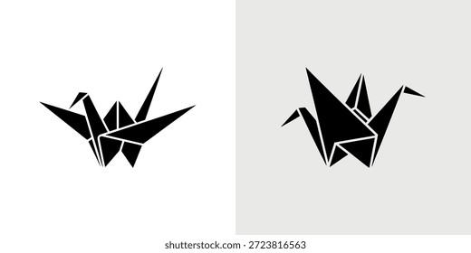 Grúas de origami negras mostradas en dos poses distintas contra un fondo blanco sólido.